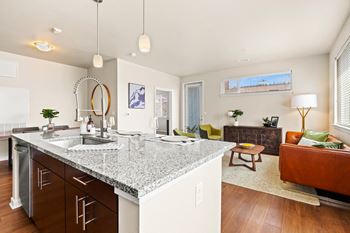a kitchen with a granite counter top and a living room